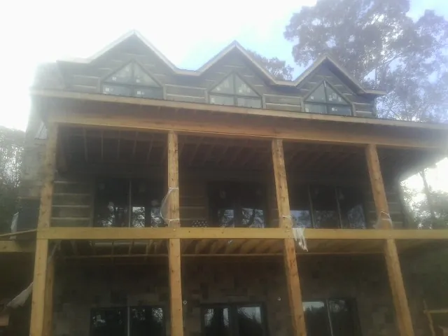 Dormers and porch framing on a large log home under construction — Roof Coating work by our crew in Palisades